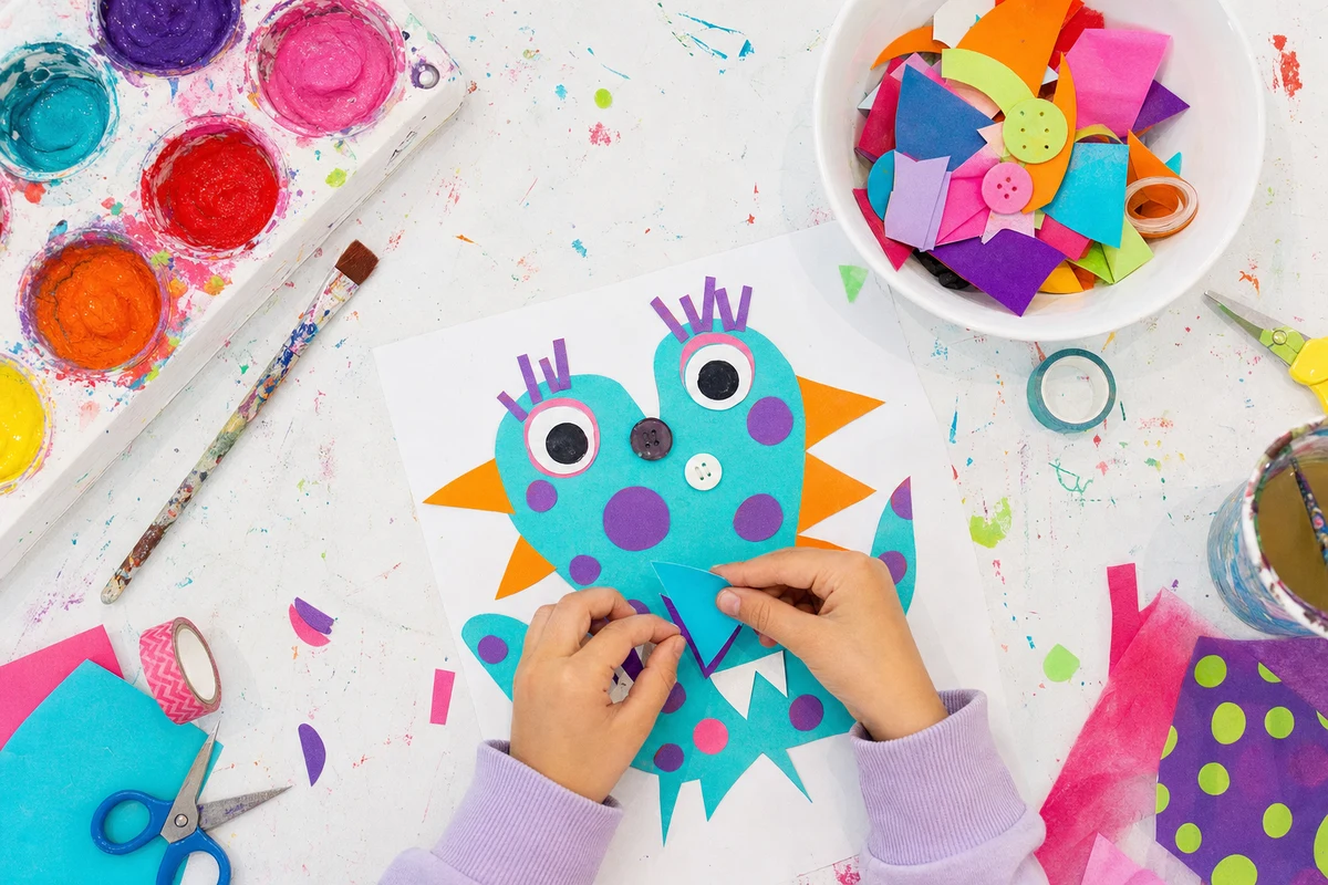 Two hands moving a paper triangle into place on a shape creature